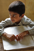 Young boy reading braille